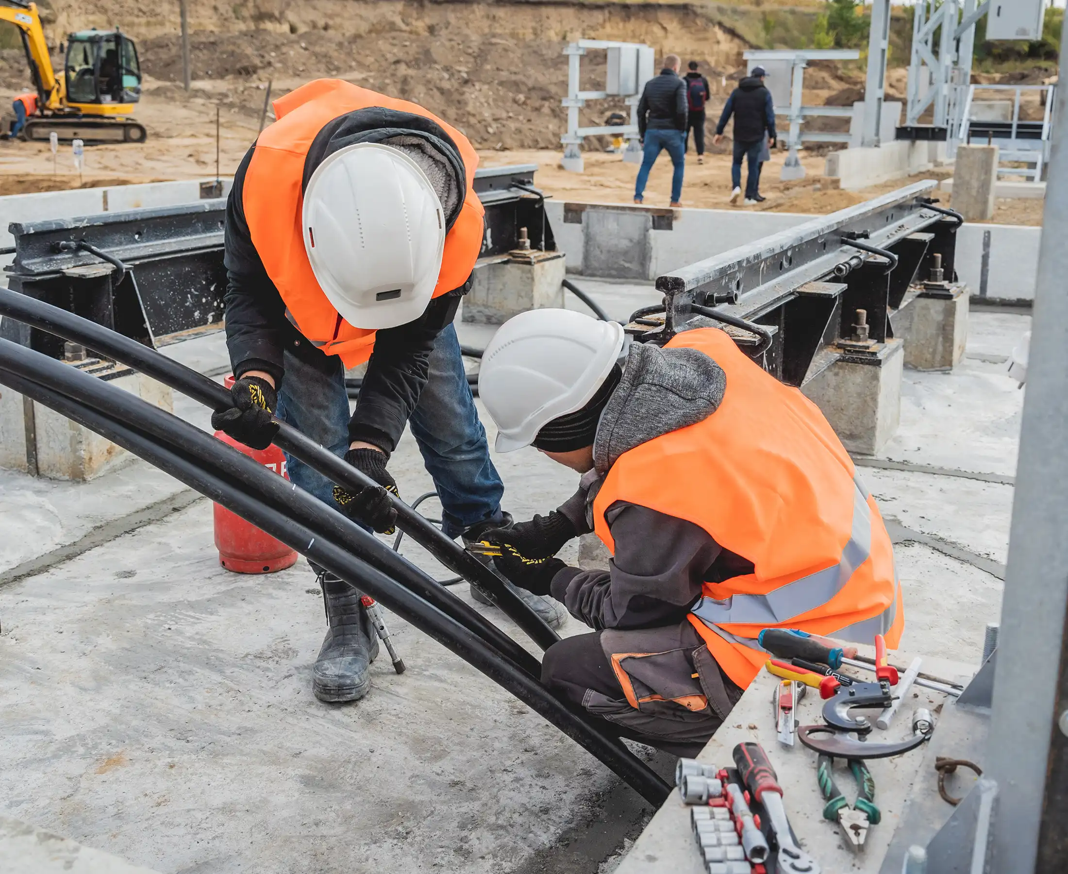 Two electrician builder workers installing high-voltage cable
